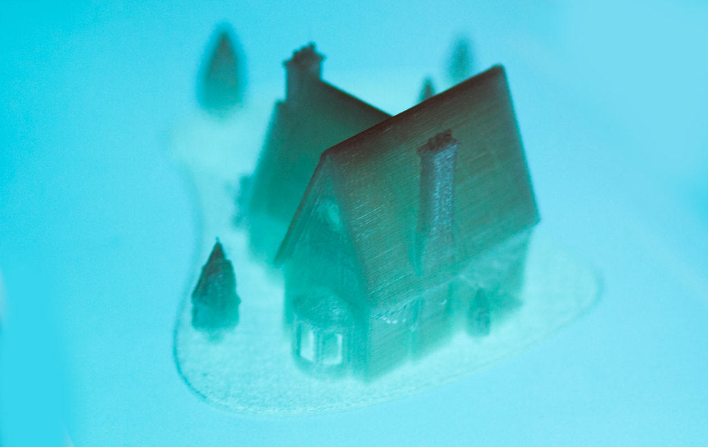 Casa natalizia stampata in 3D con lago ghiacciato