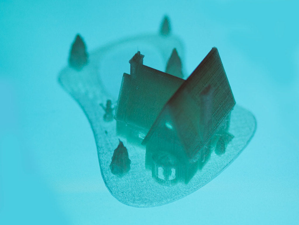 Casa natalizia stampata in 3D con lago ghiacciato